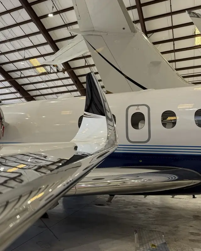 Wing and fuselage, hangar light on the paint