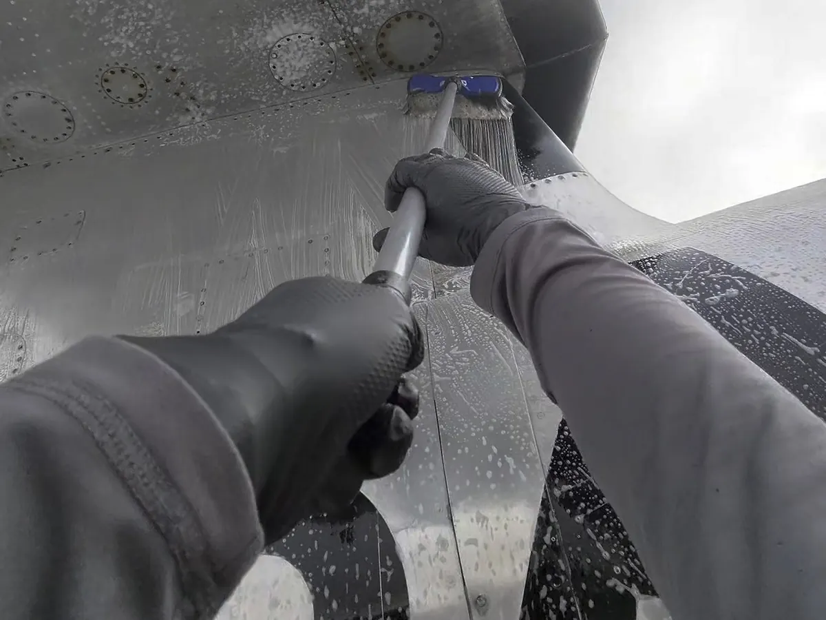 Washing the underside of an aircraft by hand, with a soft brush and foam